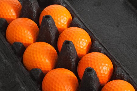 The orange golf balls in black boxの写真素材