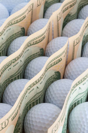 The golf balls and dollars banknotesの写真素材
