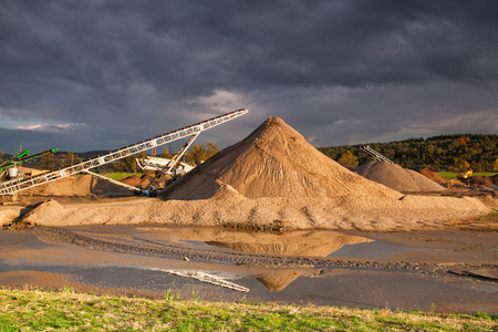 Conveyor on a bank of the river moves the sand