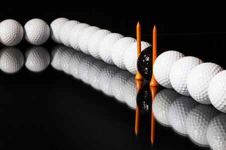 Different golf balls on the black tableの写真素材