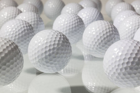 Different golf balls on a glass tableの写真素材