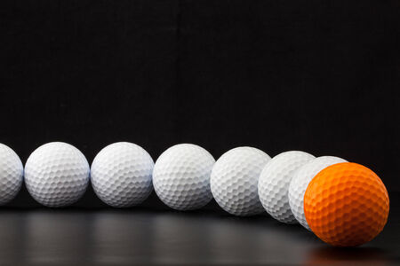 Different golf balls on the black tableの写真素材