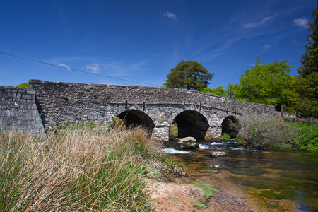 The ancient clapper bridge at Postbridges in Dartmoor National Park, Devon England UKの写真素材