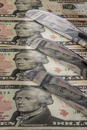 Knifes from stainless steel and US dollar banknotesの写真素材