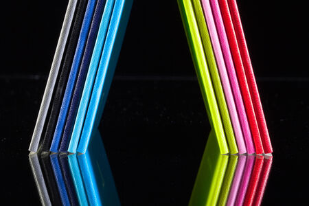 Twelve different colors diaries on a glass desk