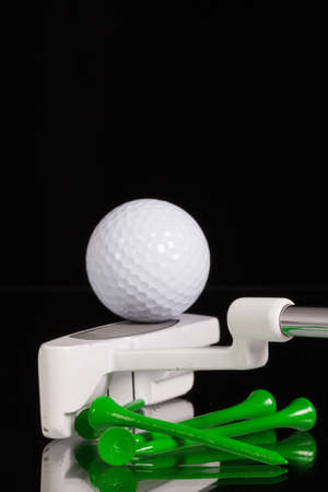 Golf putter and different golf equipments on the black glass deskの写真素材