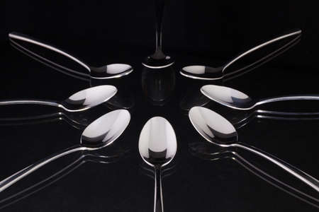 Teaspoons on the black glass deskの写真素材