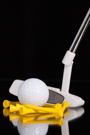 Golf putter and different golf equipments on the black glass deskの写真素材