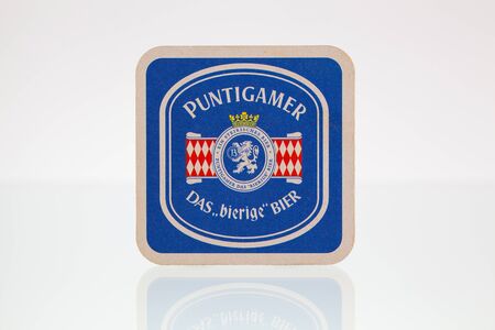 Germany,Berlin - January 7,2015:Beermat from Puntigamer beer on a glass table.Puntigamer is a Euro Pale Lager style beer brewed by Brauerei Puntigam  in Graz, Austria.のeditorial素材