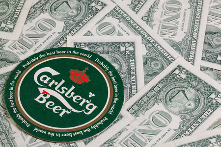 England, London - November 11, 2014:Beermat from Carlsberg beer and US dollars.The Carlsberg is a...