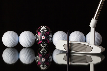 Golf equipments and egg on a black glass deskの写真素材