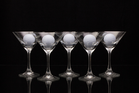 Five glasses of champagne with golf ballsの写真素材
