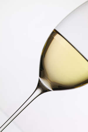 Wineglass with white   wine on a white backgroundの写真素材