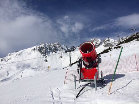 Modern red snow cannon near the ski piste in the high mountainsの写真素材