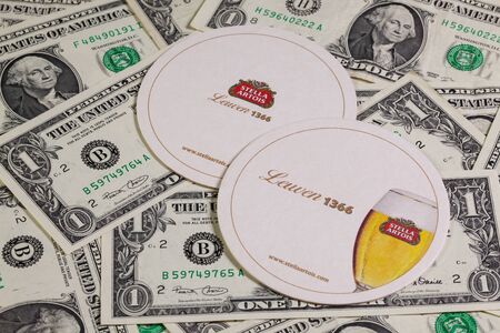 England,London - November 11, 2014:Beermats from Stella Artois and US dollars.It has been brewed in...