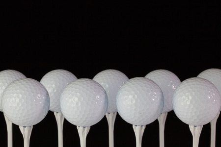 White golf balls on a white plastic teesの写真素材