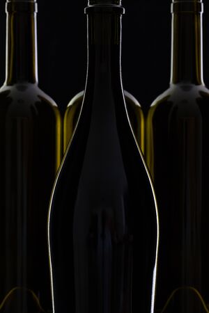 Four different bottles of wine on the black glass.の写真素材