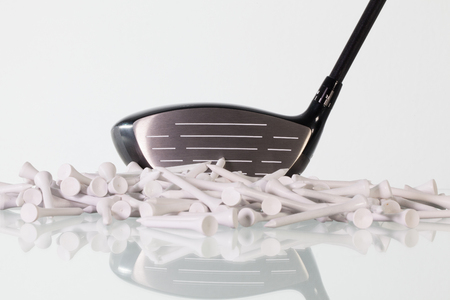 Golf driver and wooden tees on a glass tableの写真素材