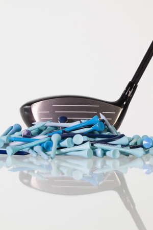 Golf driver and wooden tees on a glass tableの写真素材