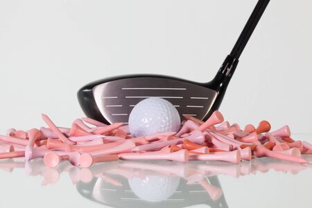 Golf driver and wooden tees on a glass table