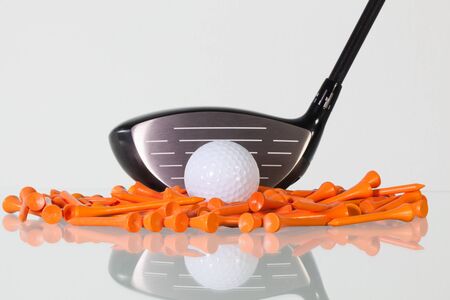 Golf driver and wooden tees on a glass tableの写真素材