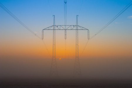 Silhouette of high voltage electrical pole structure in the morning mistの写真素材