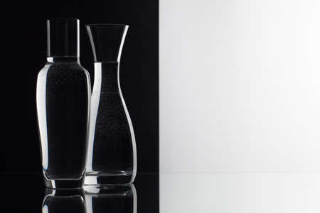 Glasses of water on the black and white background on the glass tableの写真素材