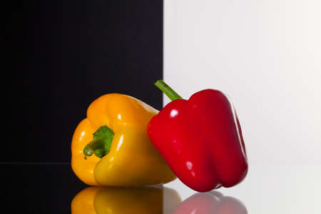 Two peppers  isolated on black and white background and glass deskの写真素材
