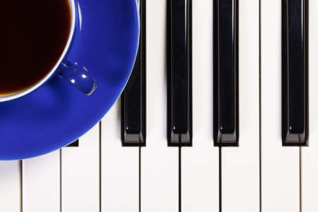 Detail of piano keyboard and cup of coffeeの写真素材
