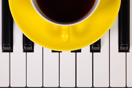 Detail of piano keyboard and cup of coffeeの写真素材