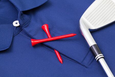 Detail of blue polo shirt and golf equipments