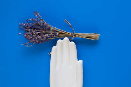 Detail of ceramic hand and bouquet lavender flower on the blue wooden table - Flat Lay Photographyの写真素材