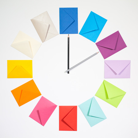 Twelve envelopes isolated on white background. Clock of colored envelopes for Christmas mailing.の写真素材