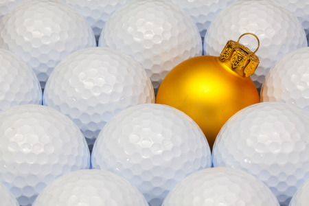 Gold  Christmas decoration between the white golf ballsの写真素材
