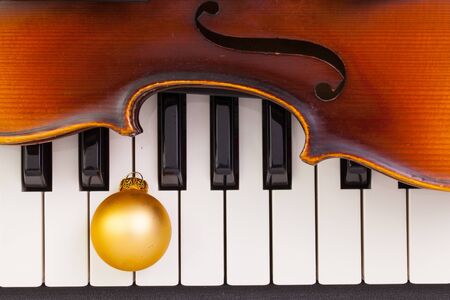 Top view close up shot of piano keyboard,old violin and Christmas decoration. Flat Lay Image
