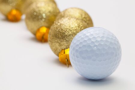 Golf ball and Christmas decoration on the white tableの写真素材