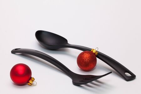 Black fork and spoon and christmas decoration on the white table