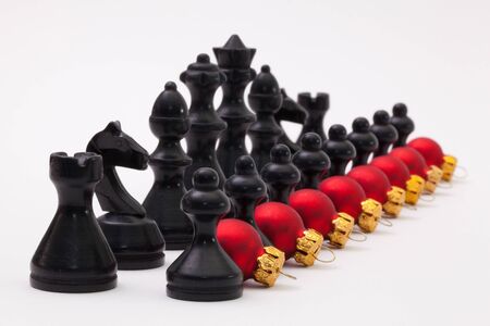 Black chess figure and red Christmas decoration on the white backgroundの写真素材