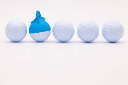 White golf balls with funny cap on the white background. Funny golf concept.の写真素材