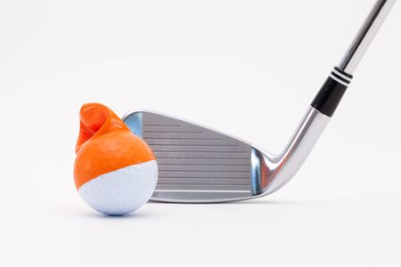 White golf ball with funny cap and golf club on the white background. Funny golf concept.の写真素材