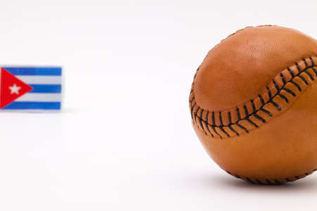Leather baseball ball and Cuban flag on the white tableの写真素材
