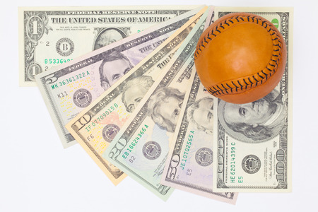 Leather baseball ball and us dollar banknotes on the white table. Flat lay photographyの写真素材