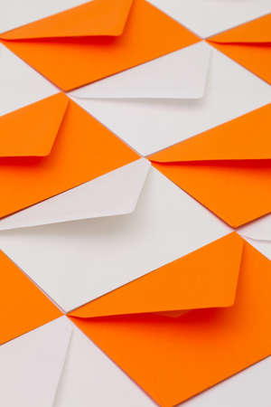 Composition with white and orange envelopes on the table.の写真素材