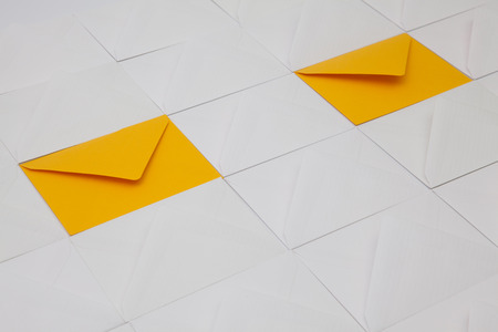 Composition with white and yellow envelopes on the table.