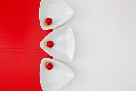 Ceramic bowls for sushi food and Christmas decoration on the white and red wooden tableの写真素材