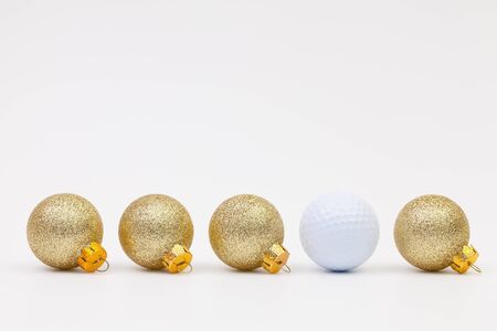 Gold Christmas decoration and white golf ball on the white backgroundの写真素材
