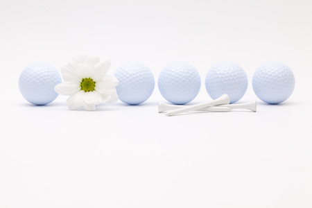 White golf balls and sping flower on the white tableの写真素材
