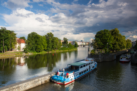 Prague, Czech Republic - June 23, 2015: Tourist boat floating on the Vltava river before storm. One of the many tourist attractions of Prague.のeditorial素材