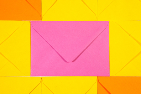 Pattern from orange, yellow and pink  envelopes on the table