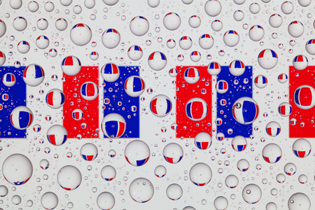 Flags  of France behind a glass covered with raindrops.の写真素材